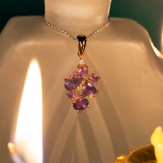 18k rose gold pendant with 1.45ctw natural alexandrite next to a lit candle