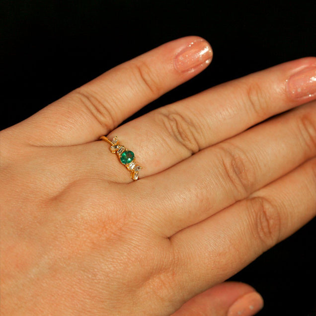 A woman's hand adorned with an 18K yellow gold stackable ring with a 0.33ct natural Alexandrite
