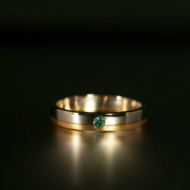 Detailed view of the 18k gold wedding band featuring a green alexandrite gemstone