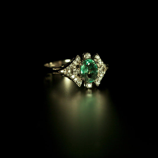 0.68ct natural alexandrite and 18k white gold ring displayed against a dark backdrop