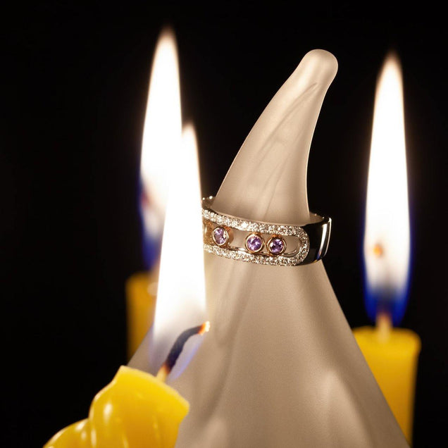 0.22ct natural alexandrite ring beside a yellow candle on a white surface