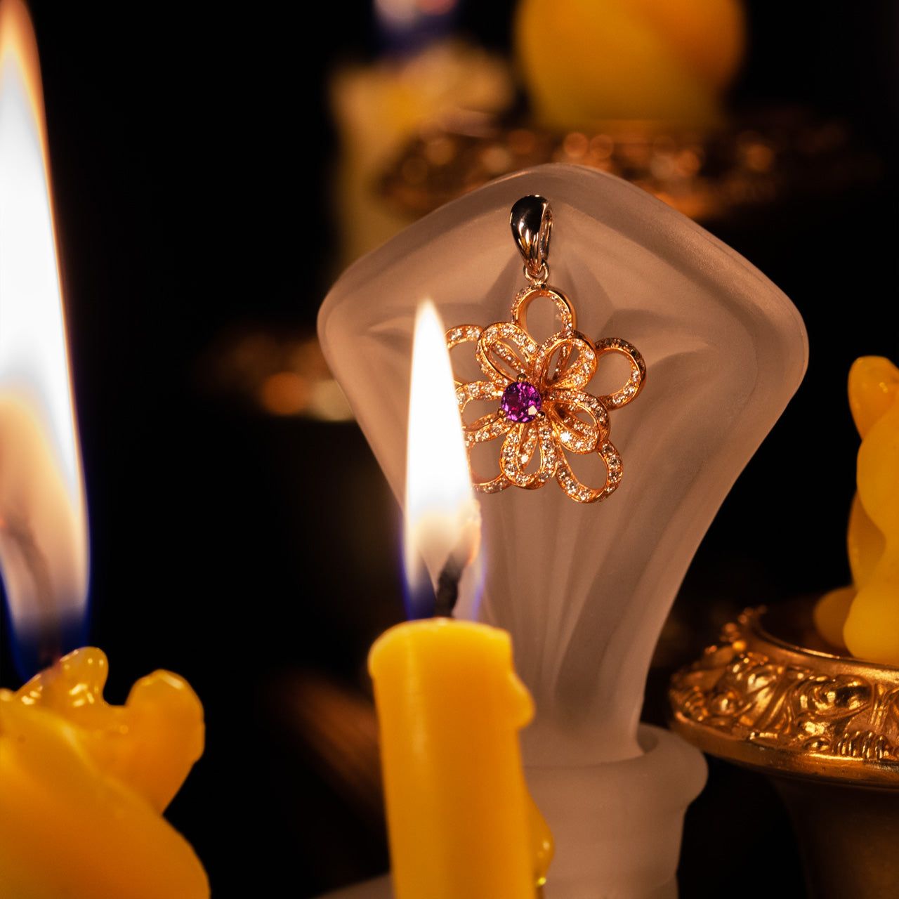 The 0.18ct alexandrite pendant in 18k gold showcased with ambient candlelight in the background