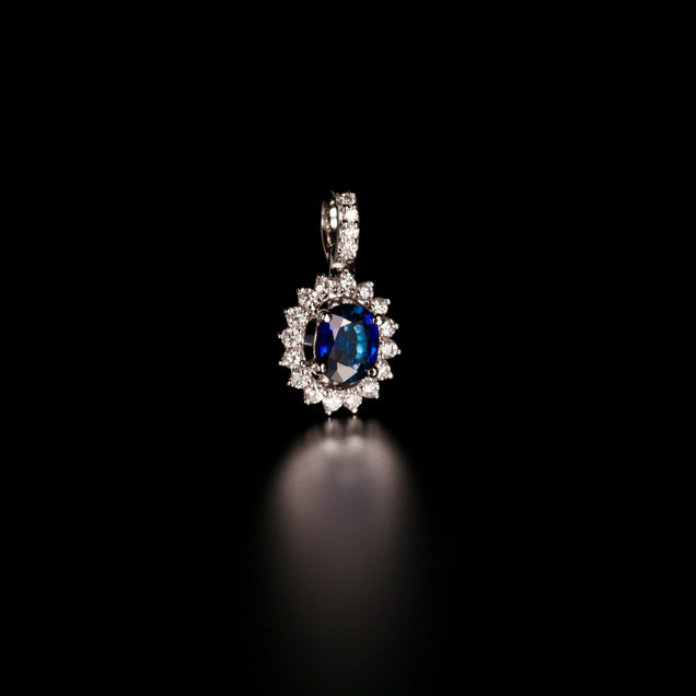 Side view of a 0.73ct blue sapphire pendant surrounded by diamonds in 18k white gold setting