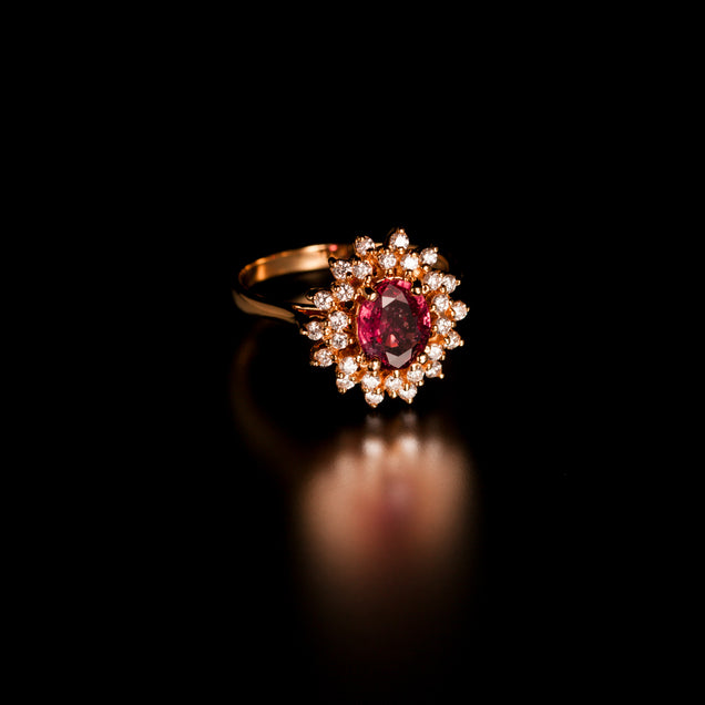 An elegant 1.28ct pink sapphire ring flanked by diamonds in an 18k yellow gold setting
