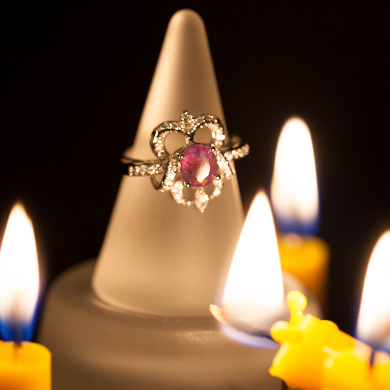 1.72ct natural alexandrite oval gemstone ring in 18k white gold with diamond accents displayed on a ring holder surrounded by candlelight