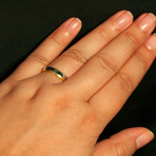 Woman's hand adorned with a size 13 wedding band crafted from 18k gold with natural alexandrite
