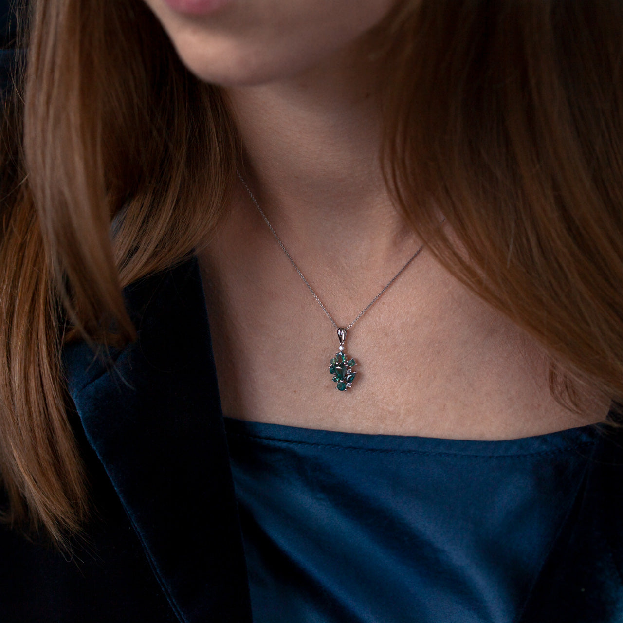 Woman in blue attire adorned with an 18k white gold alexandrite pendant