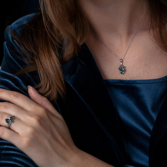 Elegant alexandrite pendant in 18k white gold worn by a woman in a blue dress