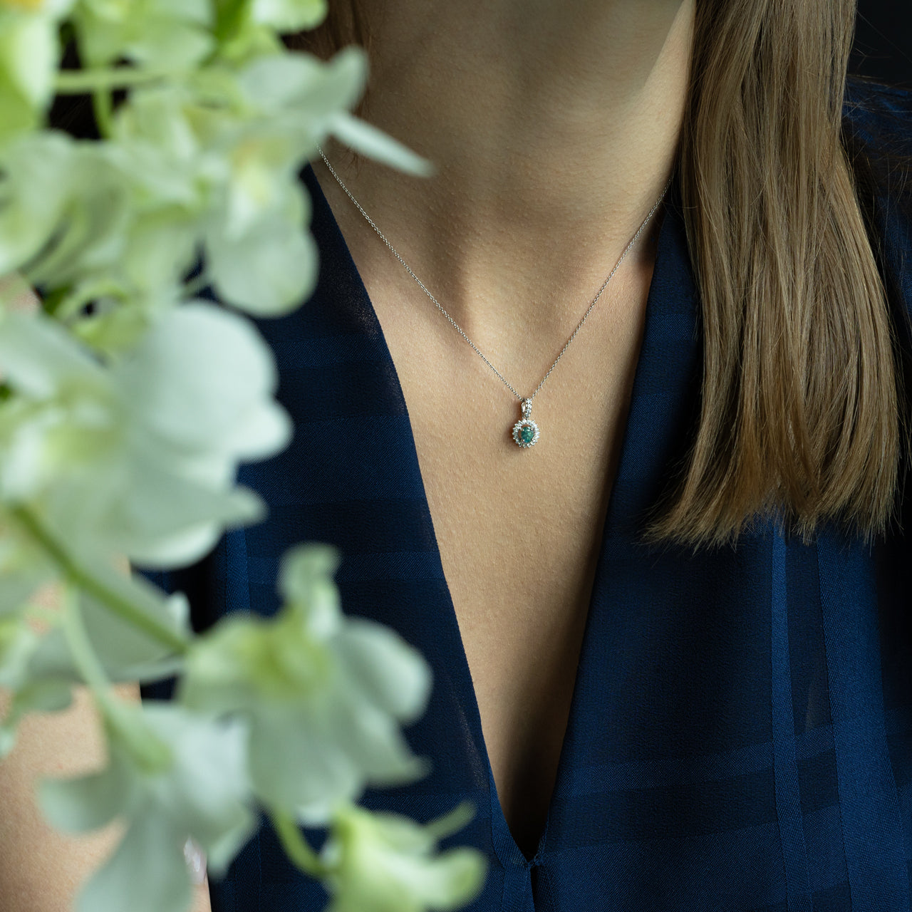 Natural Alexandrite pendant in 18k white gold with diamond halo on a woman's neck