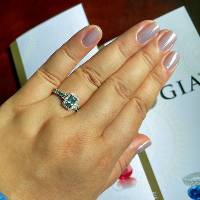 A woman's hand elegantly presenting an 18k white gold ring with a 0.95ct alexandrite