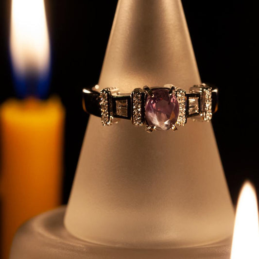A 1.30ctw natural Alexandrite ring set in 18k gold displayed on a candle