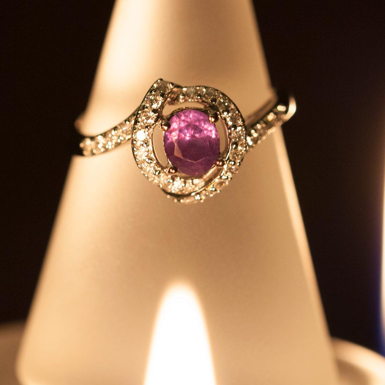An 18k gold ring with a 1.14ctw natural alexandrite stone and diamond accents displayed on a surface