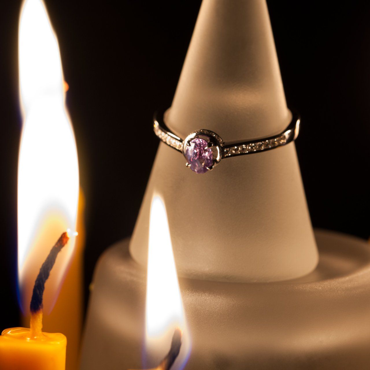 0.55ct alexandrite ring in 18k white gold resting atop a candle for display