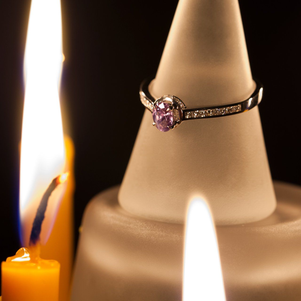 0.55ct alexandrite ring in 18k white gold resting atop a candle for display