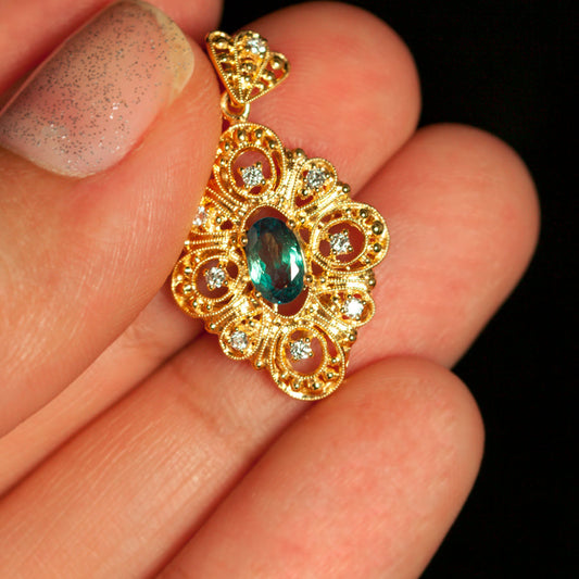 Hand presenting a 0.30ct natural alexandrite pendant in 18k yellow gold