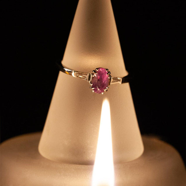 Close-up of a platinum ring with a 1.23 carat alexandrite stone on a candlelit background