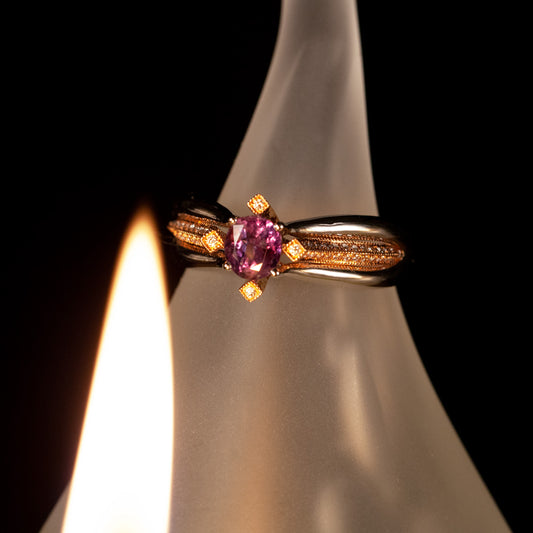 0.65ct natural alexandrite stone in 18k two-tone gold ring presented on a candle