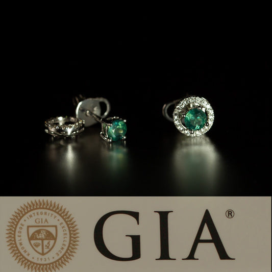 Close-up of 18k white gold alexandrite earrings with diamond jackets and certification details