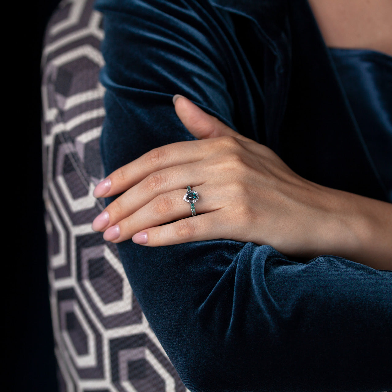 A woman in a blue velvet jacket adorned with a 0.57ct alexandrite platinum ring