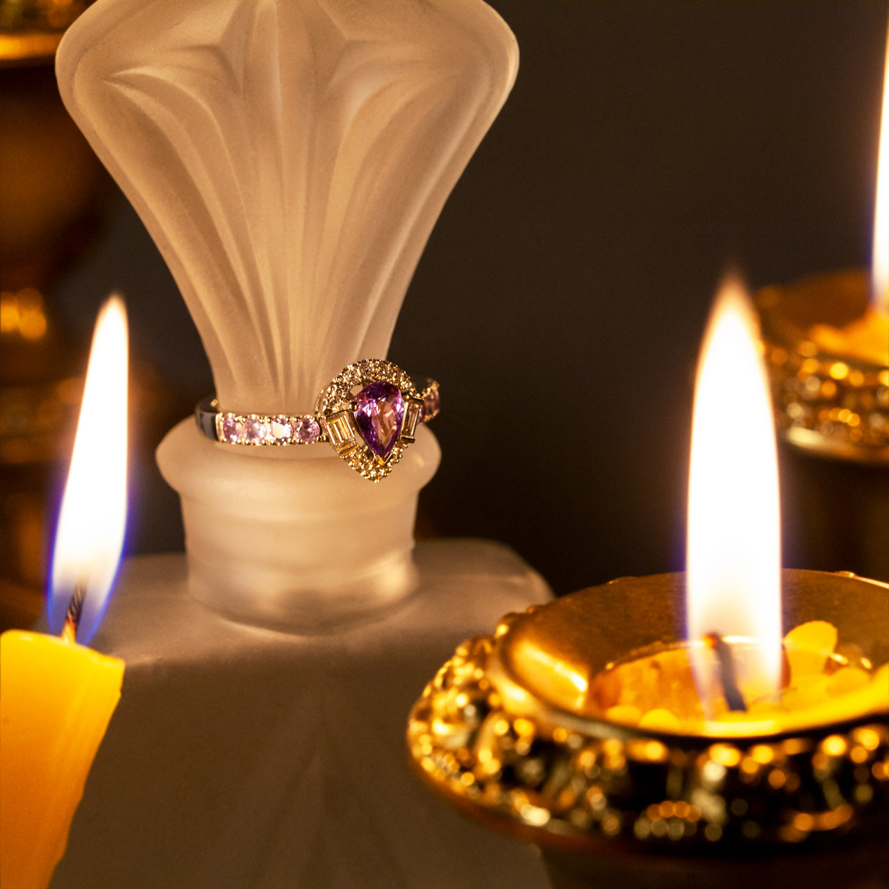A platinum ring with a 0.57ct alexandrite stone beside a flickering candle