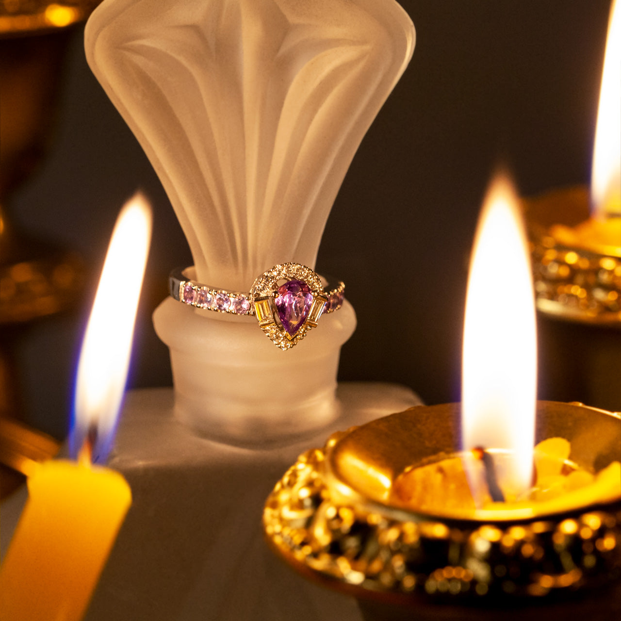 A 0.57ct alexandrite platinum ring resting atop a candle, showcasing its purple hue