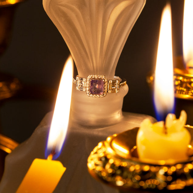 Close-up of a 1.17ct natural Alexandrite ring in 18k white gold resting atop a candle