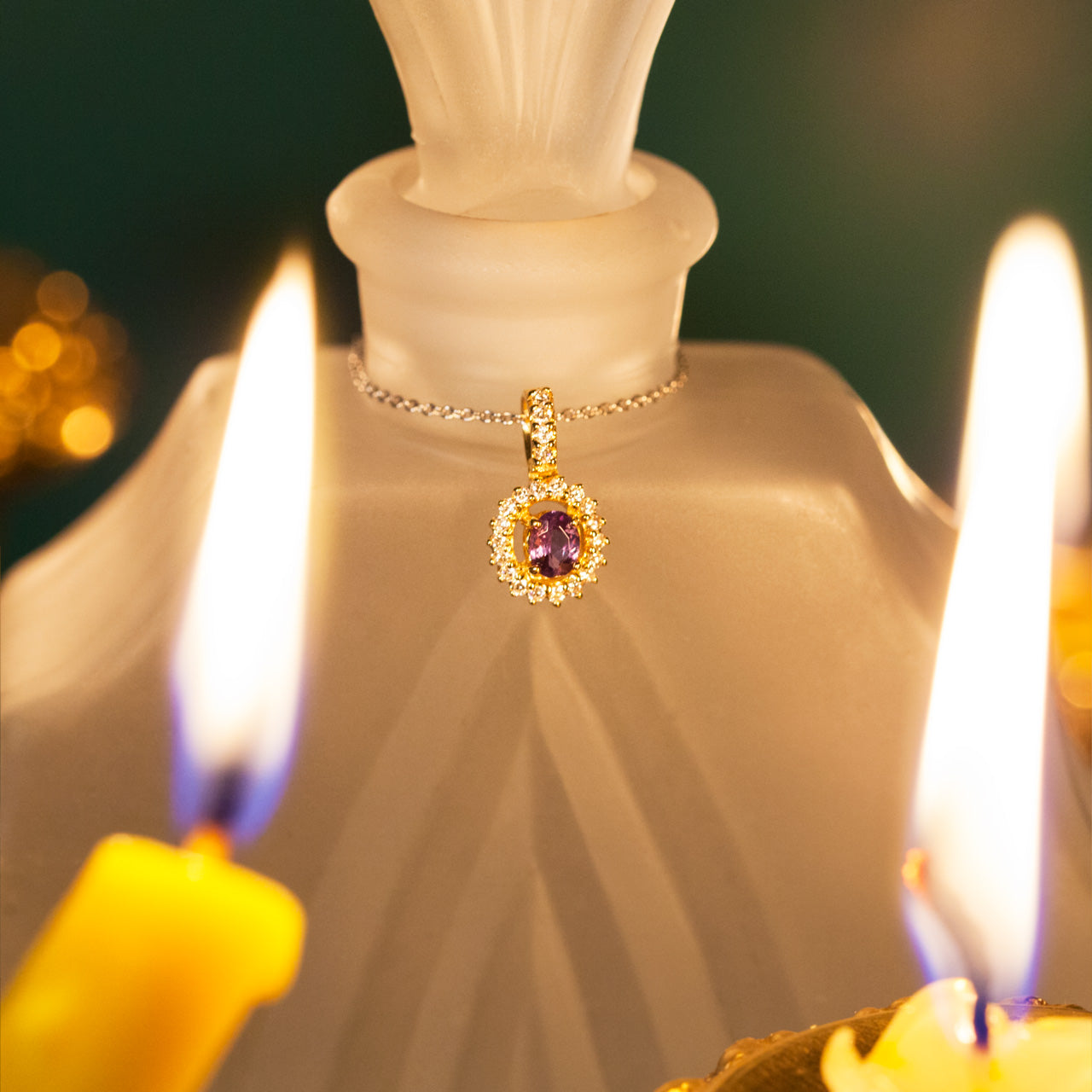 Illuminated scene with a 0.22ct natural Alexandrite 18k yellow gold pendant near a candle