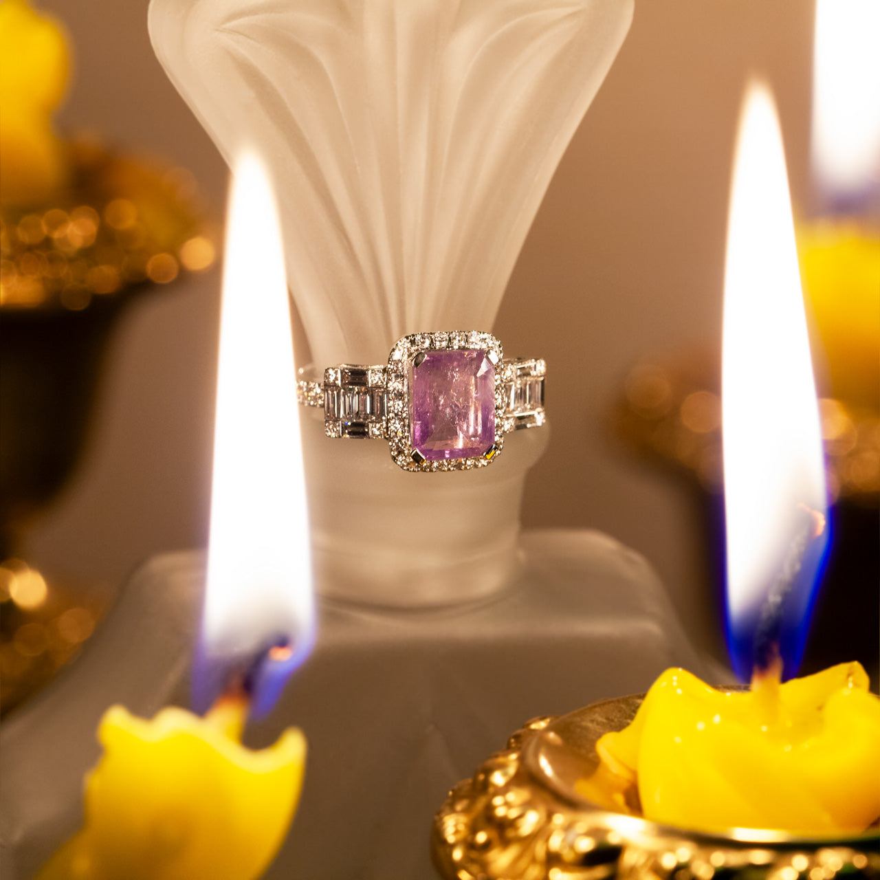 The 2.23ct natural alexandrite ring with diamond accents on 18k white gold resting atop a candle arrangement