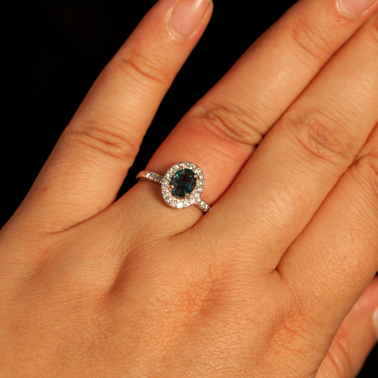 A woman's hand elegantly displaying the 0.86ct natural alexandrite and diamond ring in 18k white gold