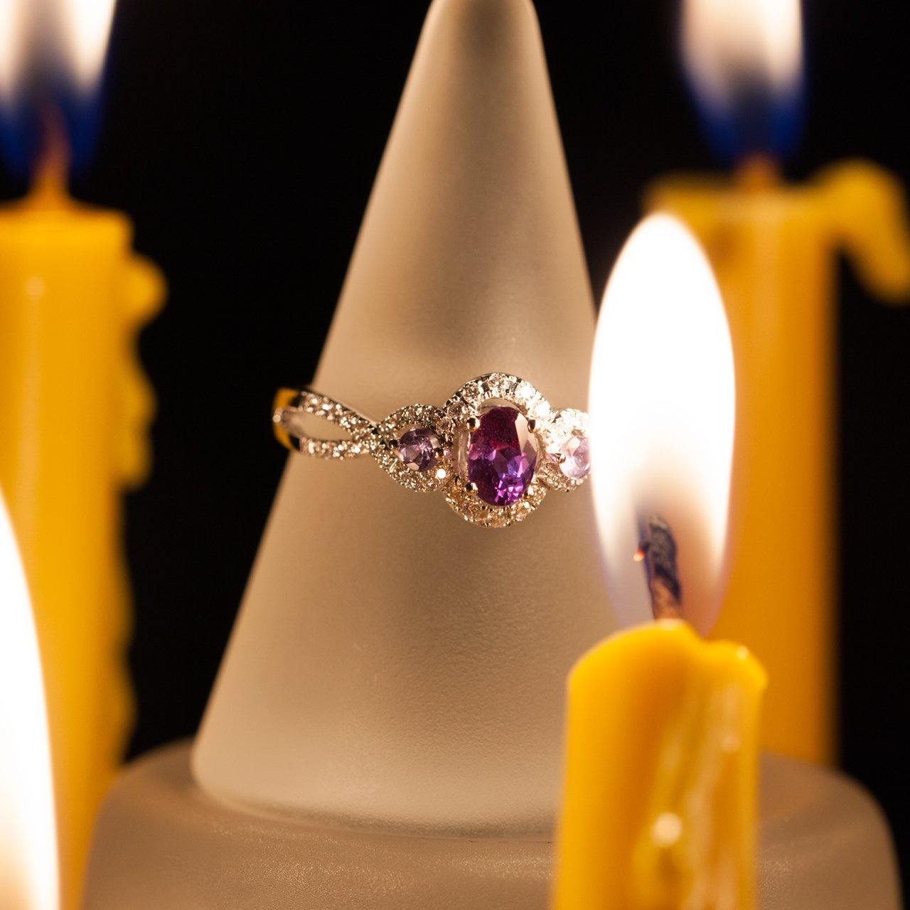 0.42ct natural alexandrite in an 18k white gold setting showcased on a candle