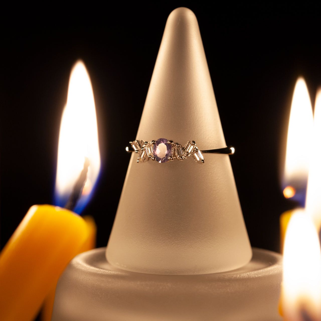 White gold ring with 0.35ct alexandrite placed on a candle holder