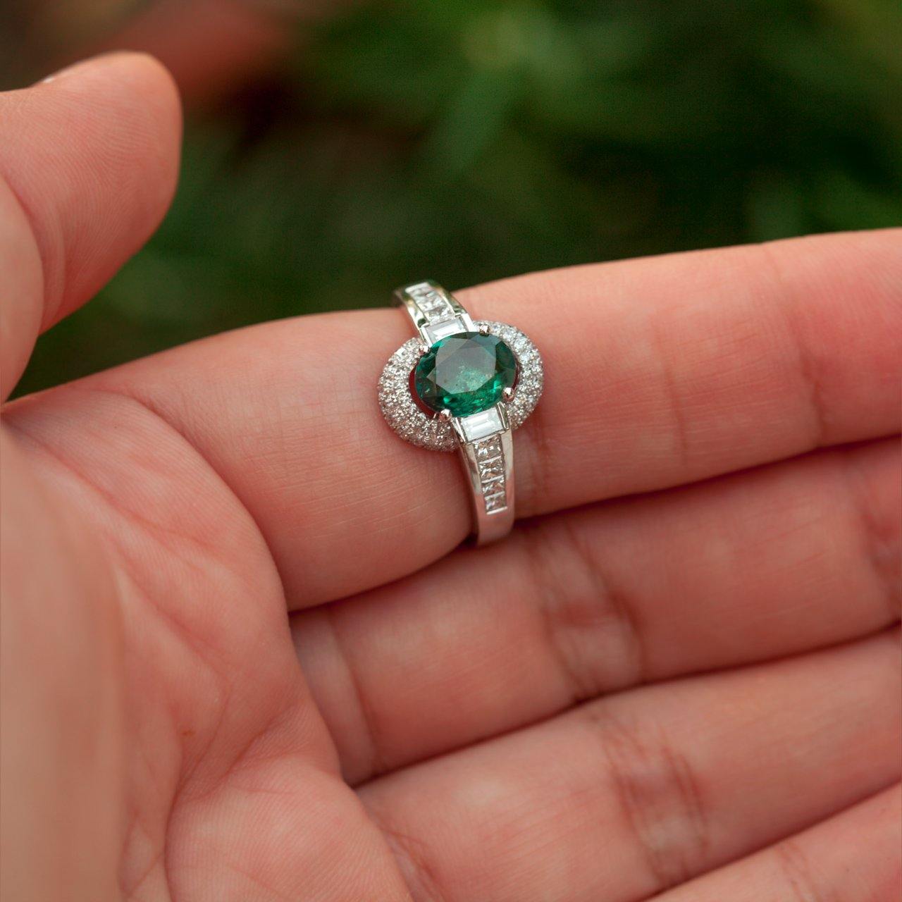 A hand presenting a 1.00ct alexandrite ring in an 18k gold setting
