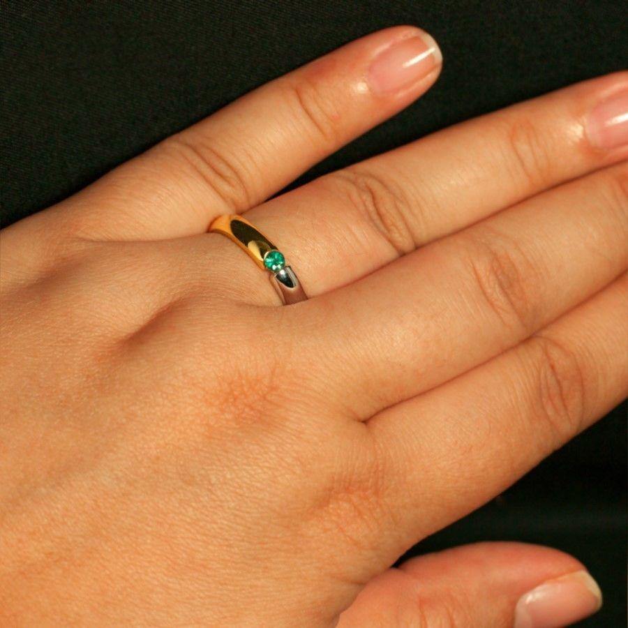 A detailed view of a woman's hand wearing the 18k gold wedding band with natural alexandrite