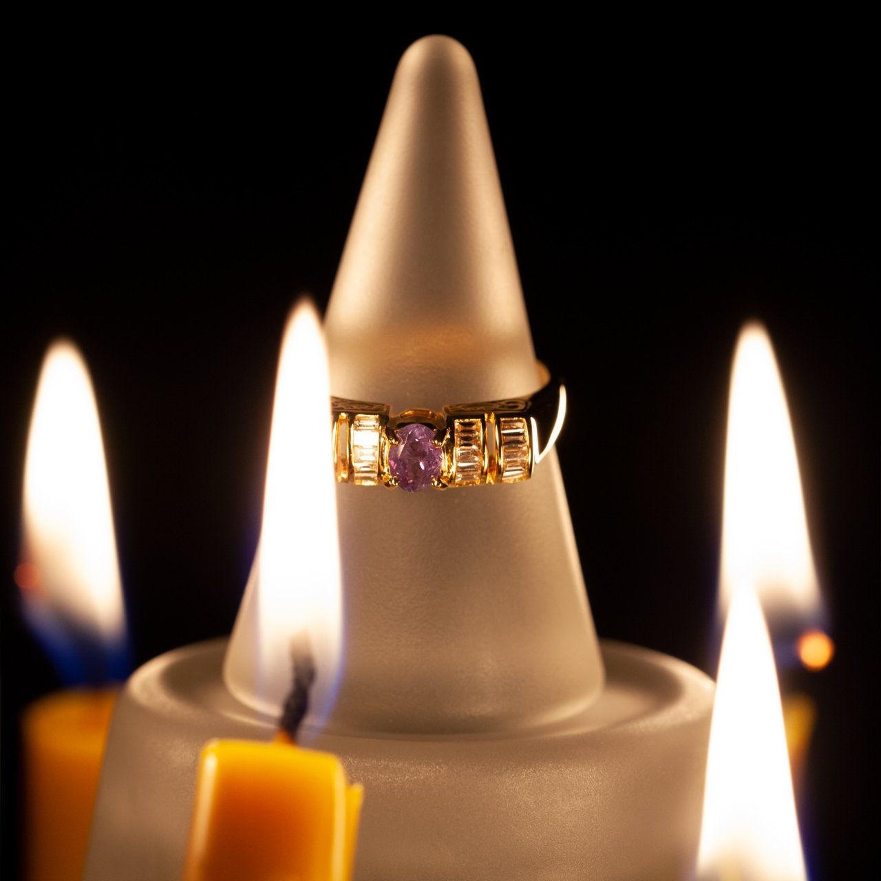 The 0.37ct alexandrite unisex ring in 18k yellow gold resting on a candle for display