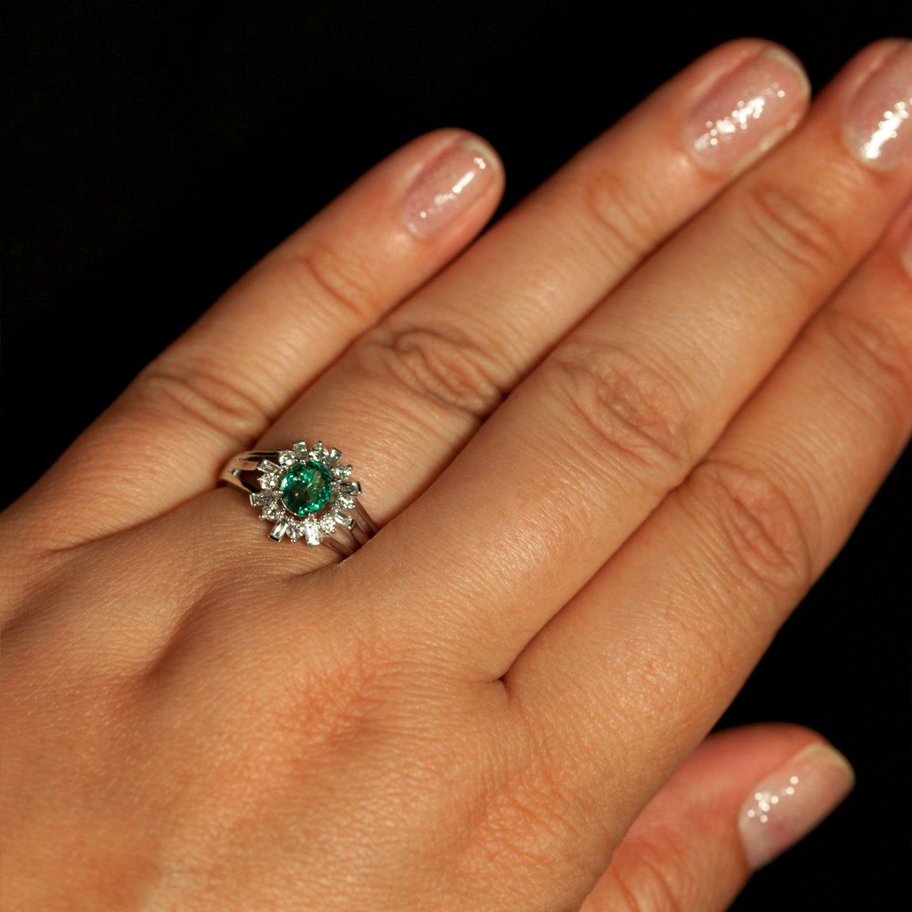 Close-up of a woman's hand displaying a 0.78ct alexandrite platinum ring with diamond accents