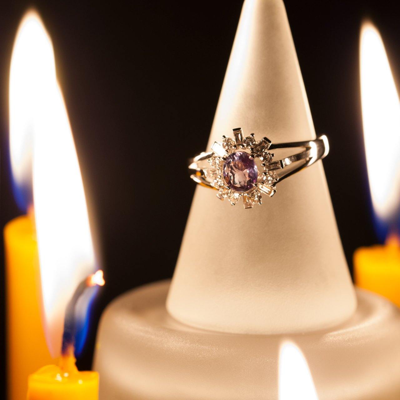 Platinum ring with a 0.78ct alexandrite perched on the edge of a candle for display