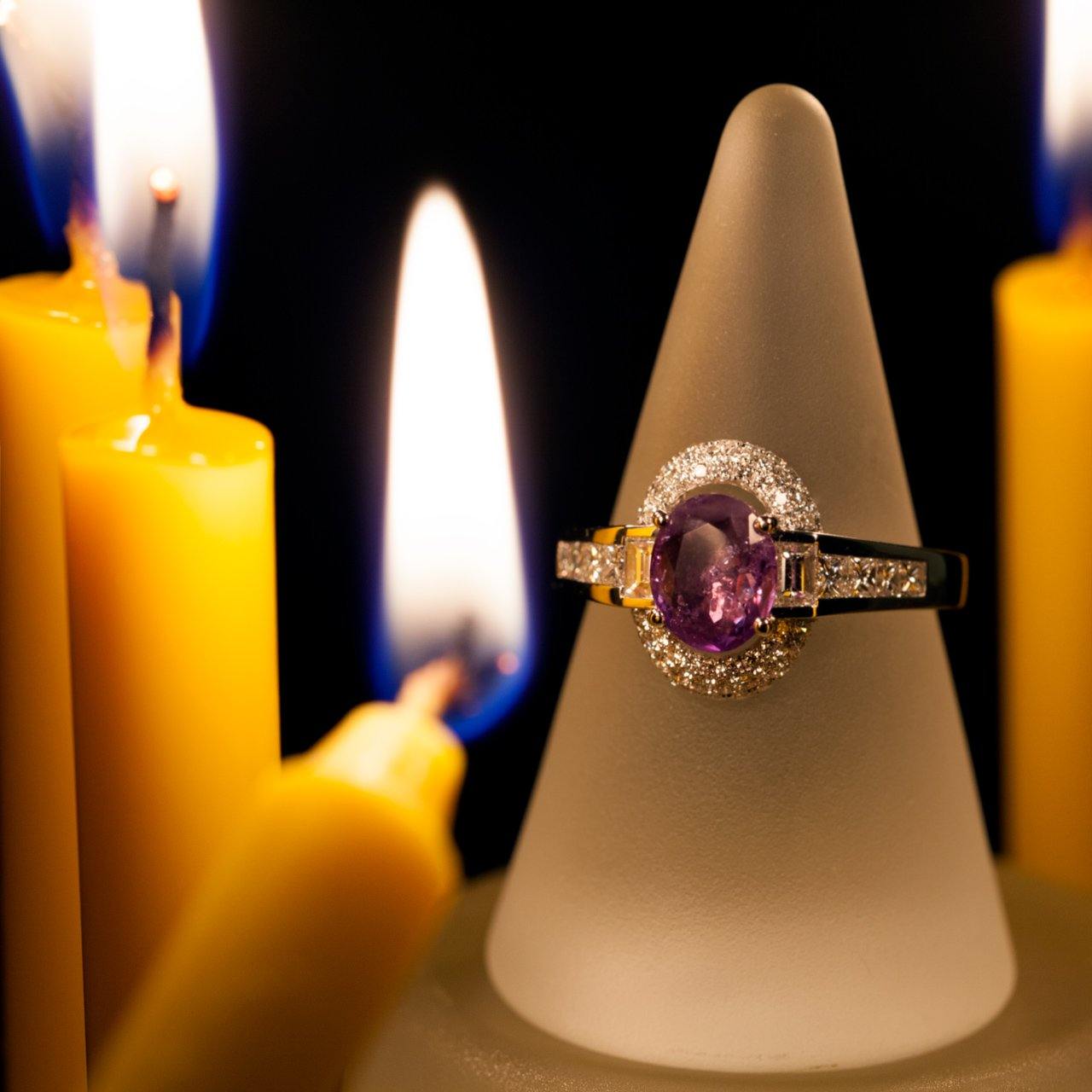 A 1.00ct alexandrite 18k gold ring resting atop a candle