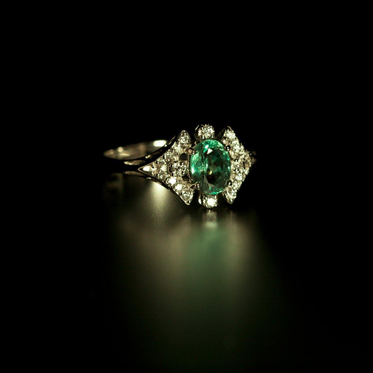 0.68ct natural alexandrite and 18k white gold ring displayed against a dark backdrop