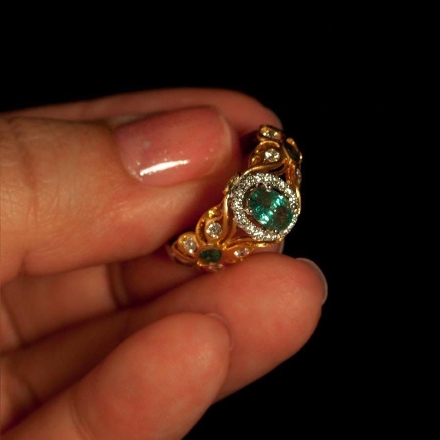 A person showcasing a 0.67ct natural Alexandrite ring set in 18k two-tone gold filigree design