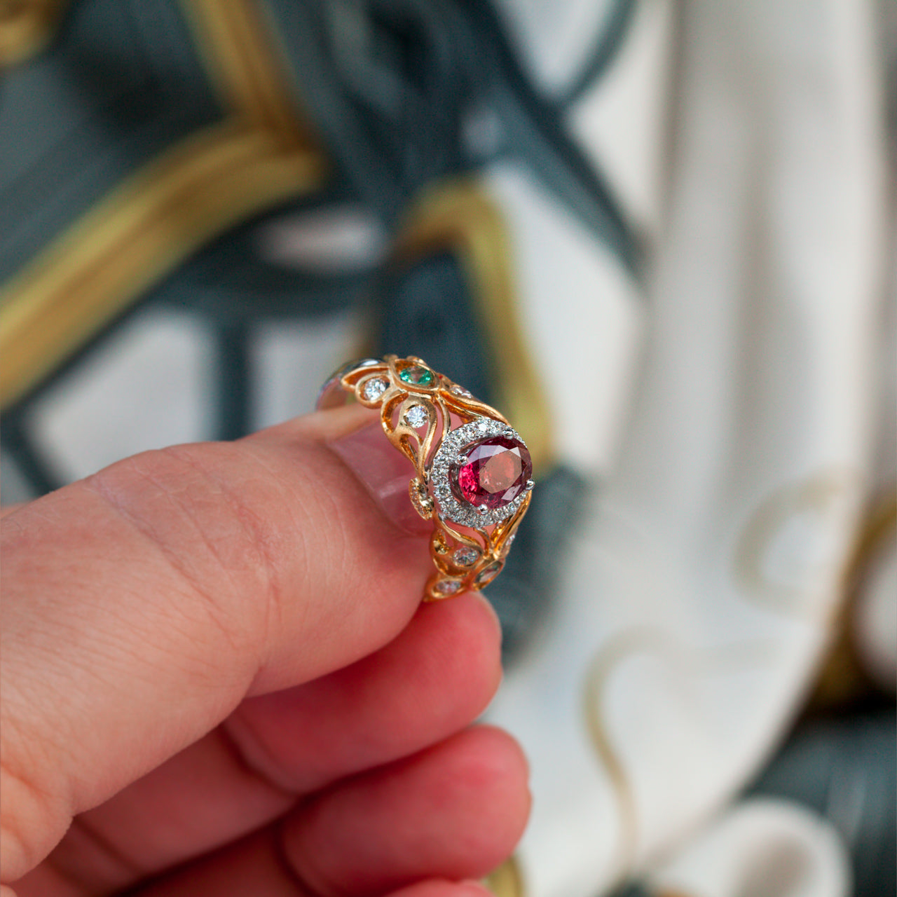 Close view of a hand presenting an 18k multitone gold ring with a 1.03ct ruby centerpiece