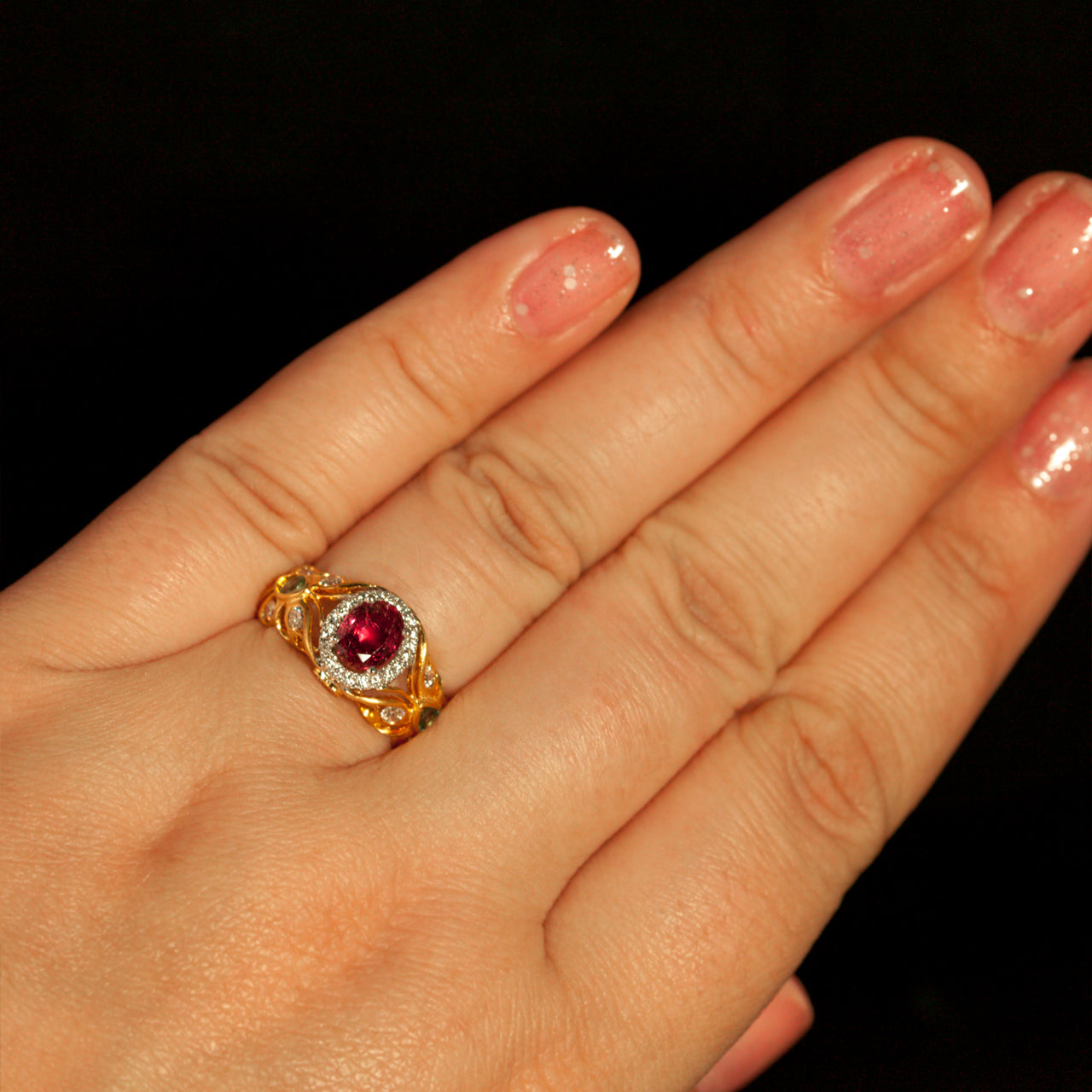 Female hand displaying a multitone gold ring featuring a 1.03ct natural ruby