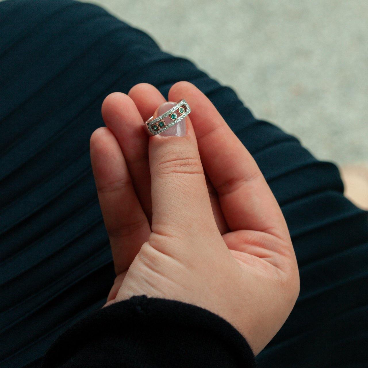Elegant 0.22ct natural alexandrite ring held between fingers showcasing the 18k white and rose gold design