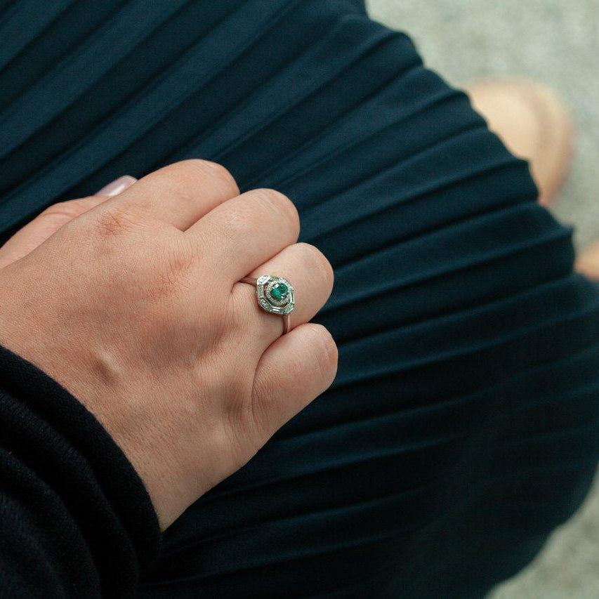 Close-up of hand wearing a vintage style natural alexandrite and diamond platinum ring on finger