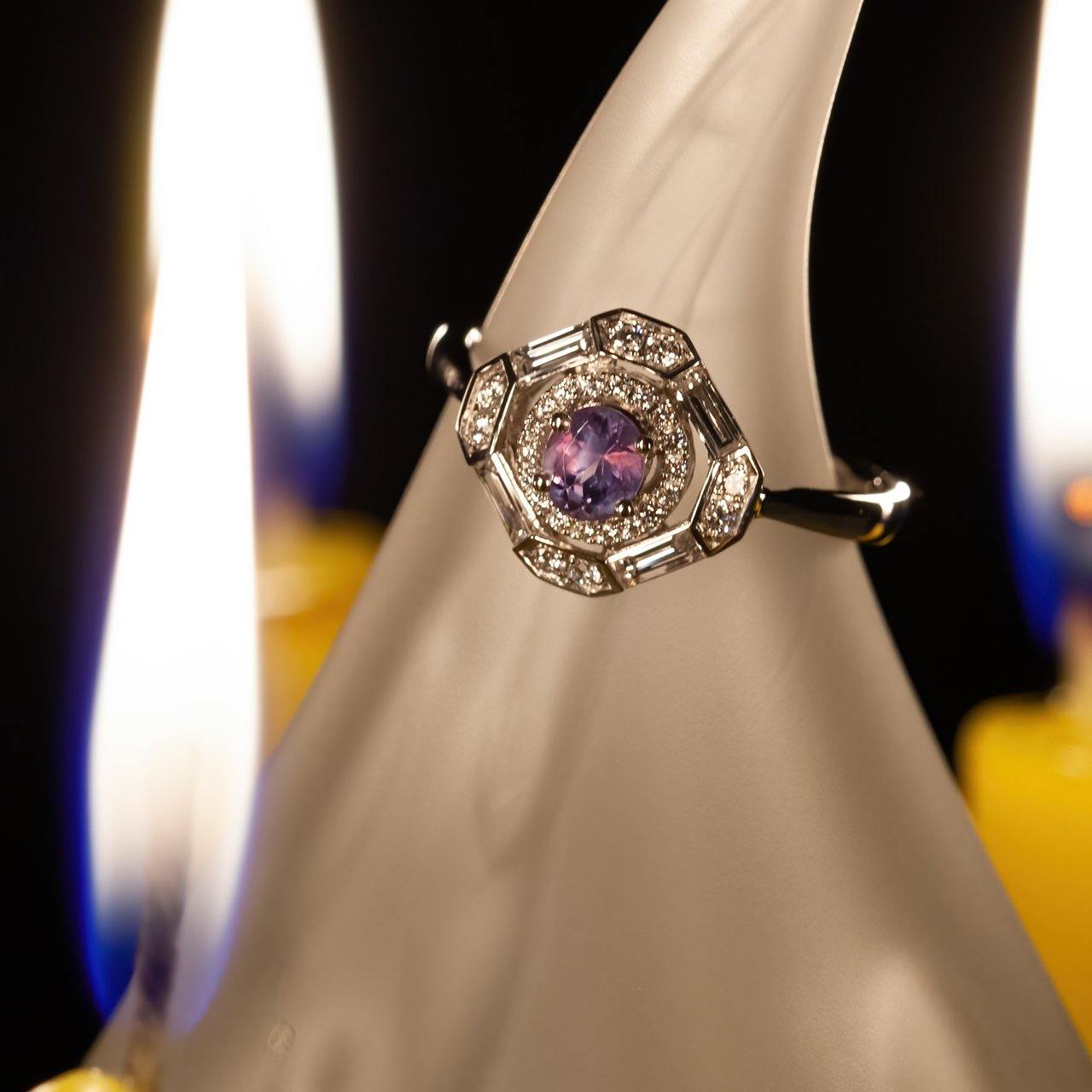 A 0.60ct alexandrite platinum ring showcased on a candle, reflecting purple hues