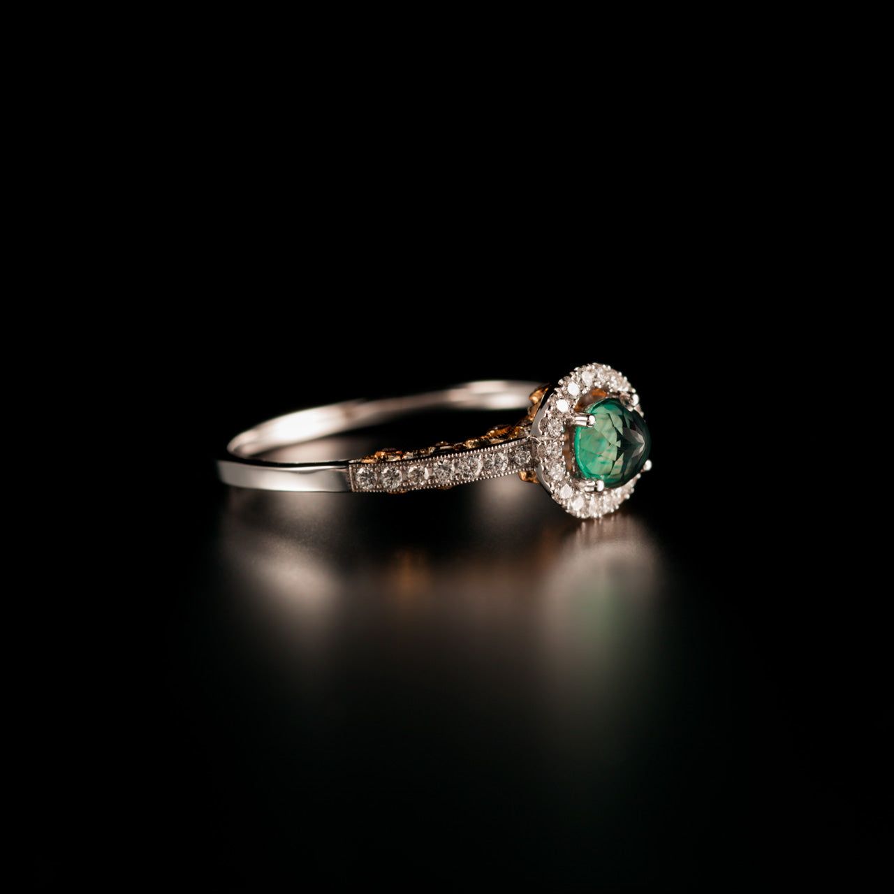 Close-up of a 0.56ct alexandrite ring in 18k white and yellow gold against a dark background