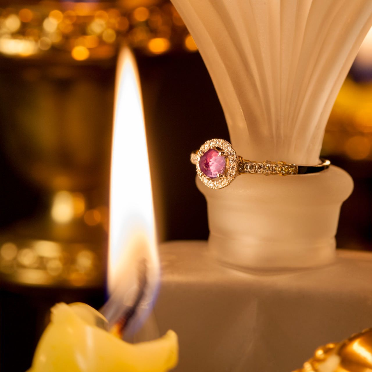 0.56ct alexandrite set in an 18k gold ring resting atop a candle