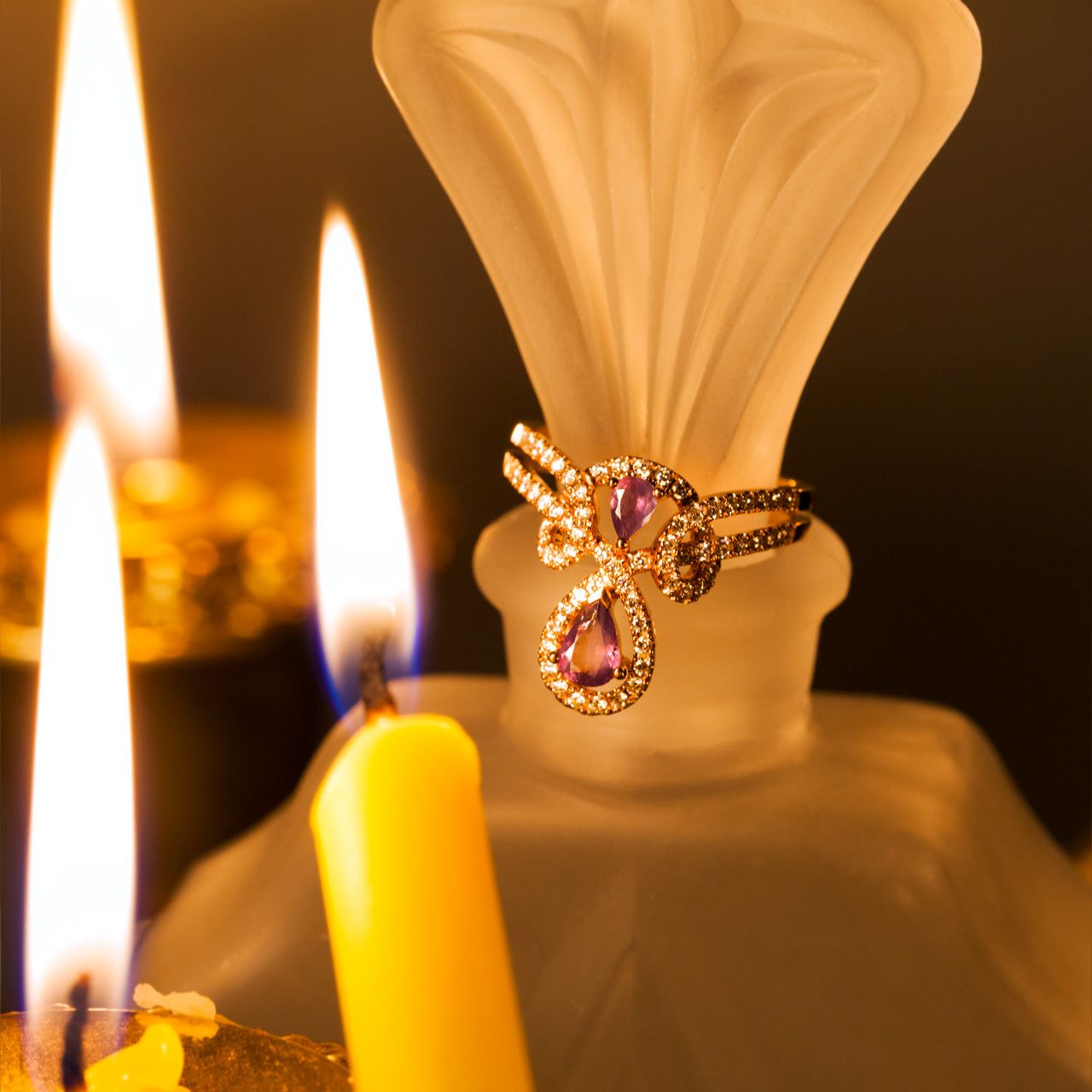 0.54ct alexandrite ring in 18k rose gold setting beside a lit candle