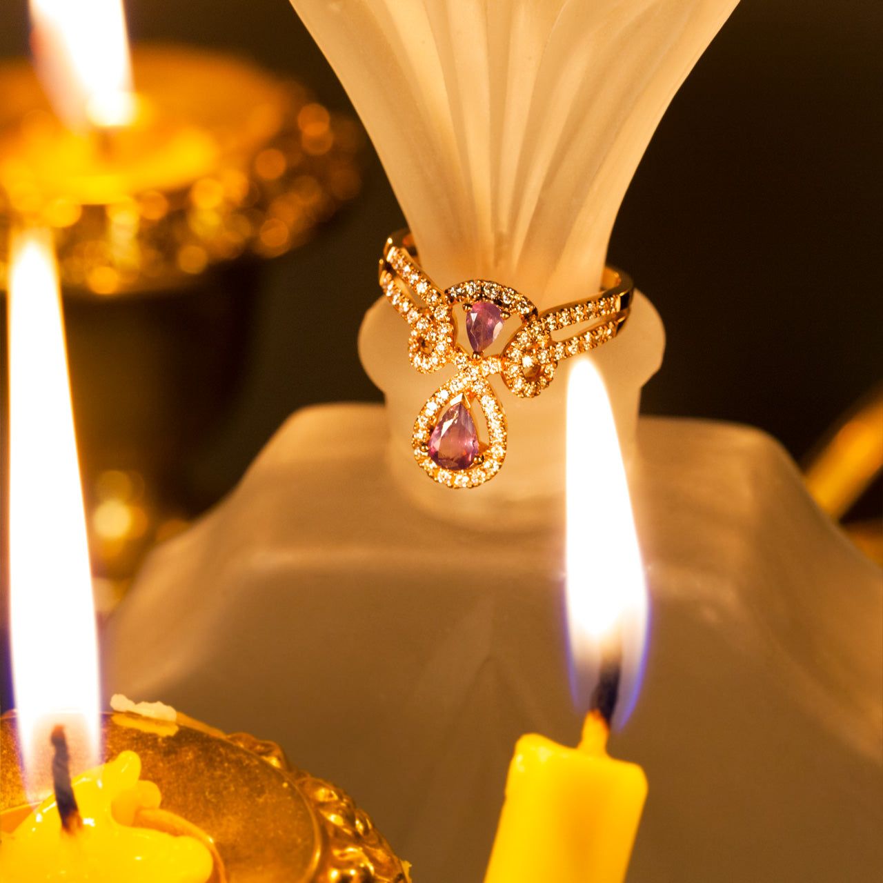 0.54ct natural alexandrite engagement ring on a table with a candle in the background