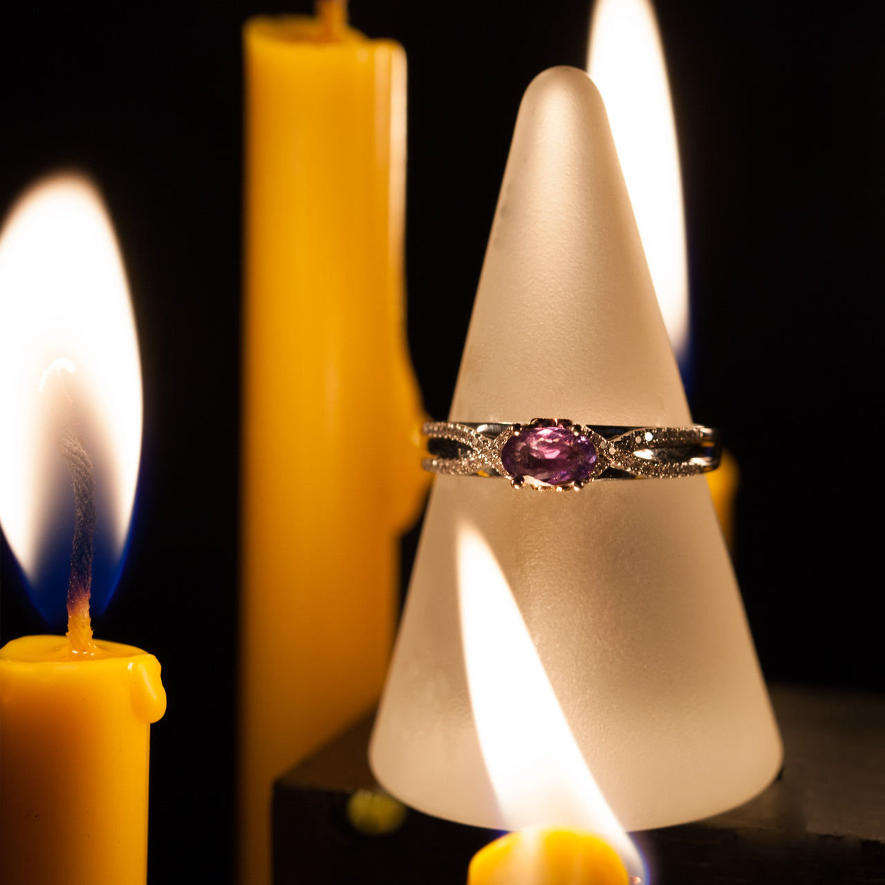 0.27ct alexandrite ring beside a candle, highlighting the 18k multitone gold setting