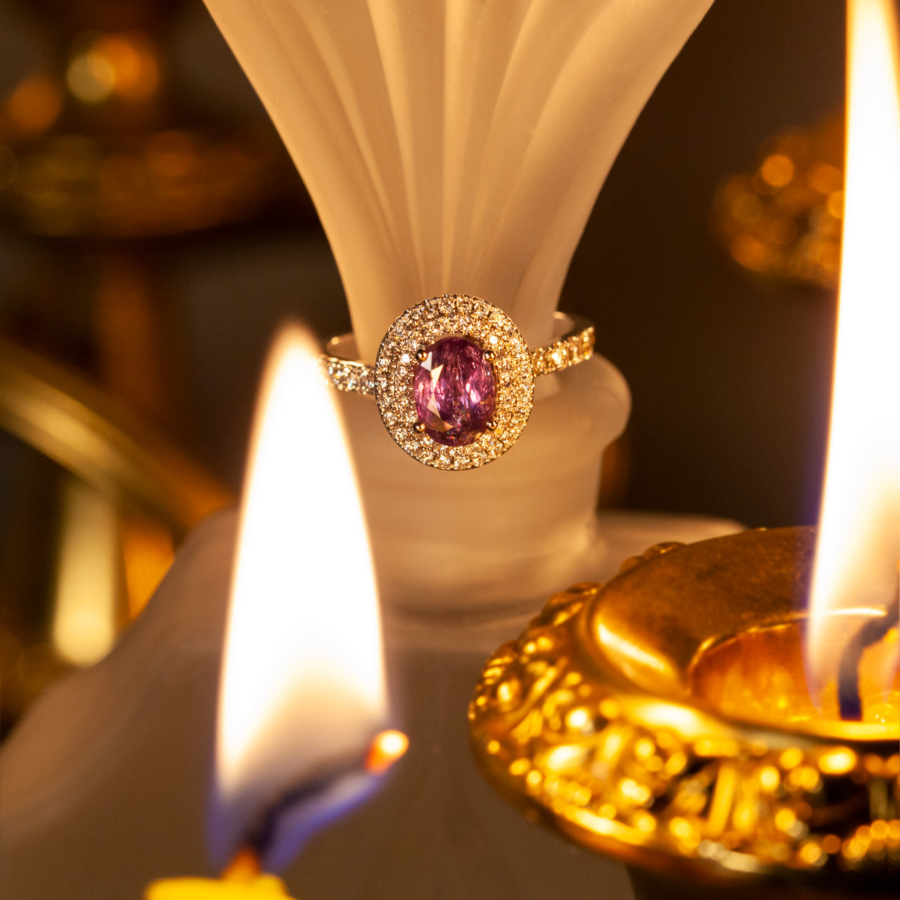 1.17ct alexandrite set in an 18k white gold band beside a decorative candle